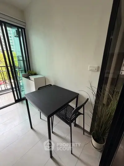 Modern balcony with sleek black table and chairs, perfect for urban living.