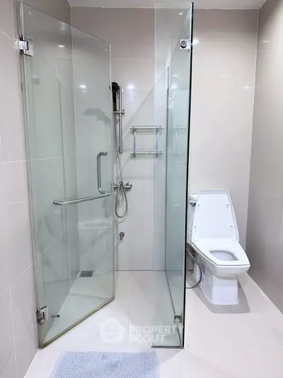 Modern bathroom with glass shower enclosure and sleek toilet design