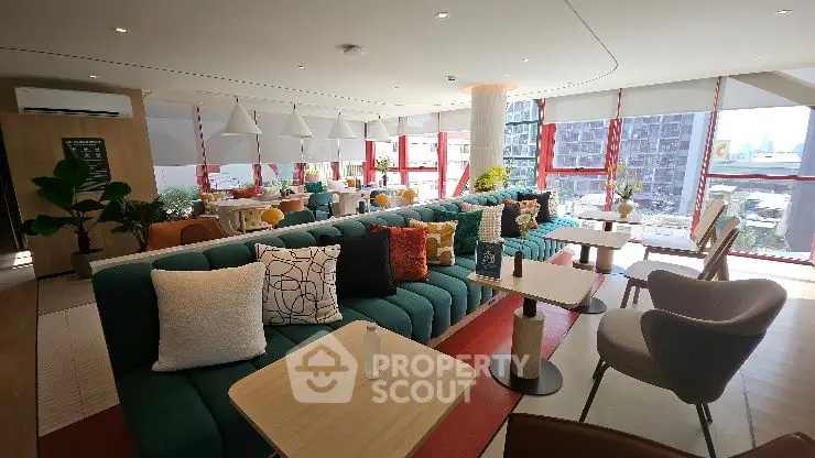 Modern living room with stylish decor and large windows offering city views.