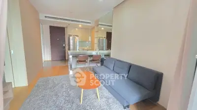 Modern living room with sleek furniture and open kitchen layout in a stylish apartment.