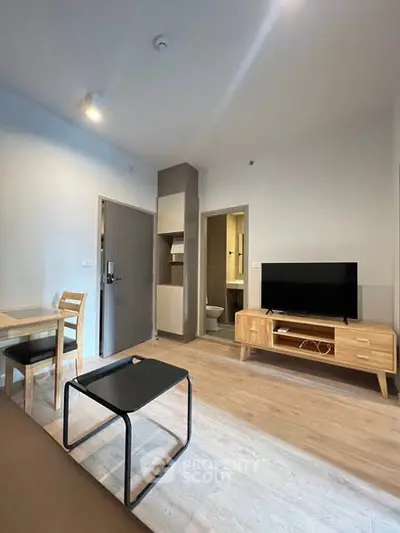 Modern living room with wooden furniture and flat-screen TV in a cozy apartment.