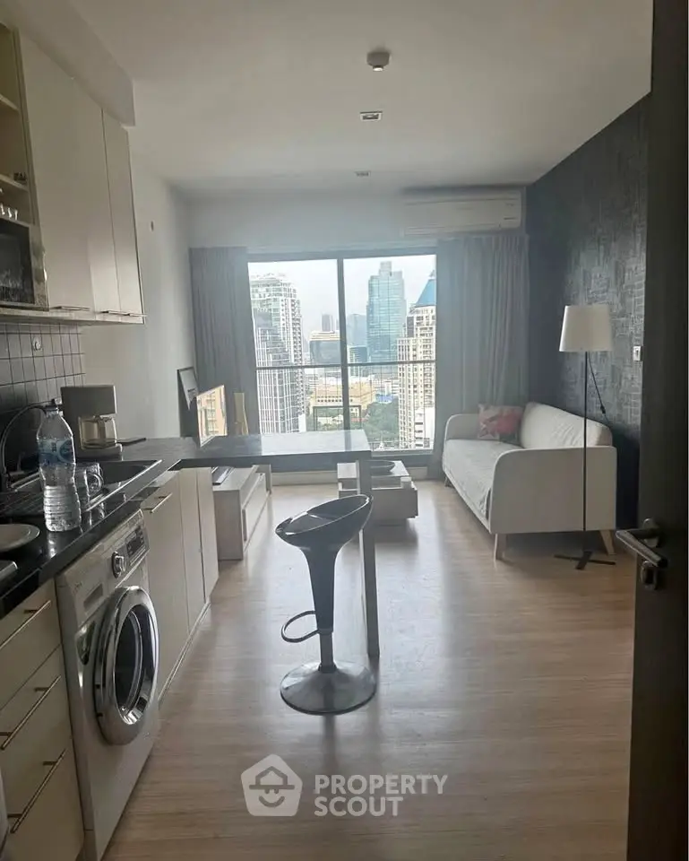 Modern open-layout living room with kitchen, city view, and stylish furnishings.