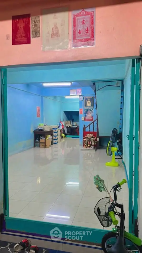 Charming interior with vibrant blue walls and open layout, featuring a staircase and decorative elements.