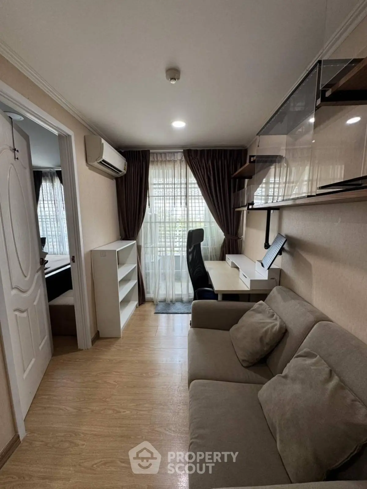 Cozy study room with sofa and desk, featuring natural light and modern decor.