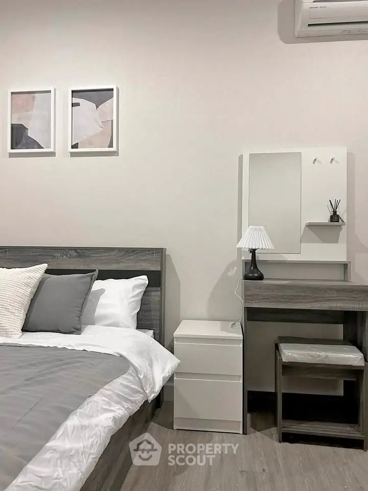Modern bedroom with stylish decor and air conditioning, featuring a cozy bed and elegant furniture.