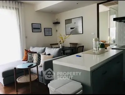 Modern living room with open kitchen, stylish decor, and cozy seating area in a contemporary apartment.