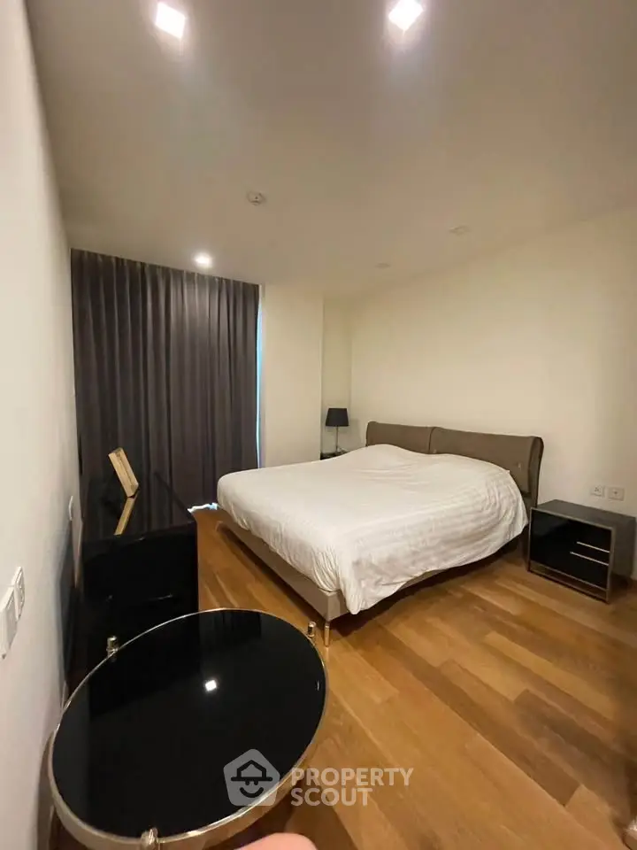 Spacious modern bedroom with wooden flooring and elegant decor