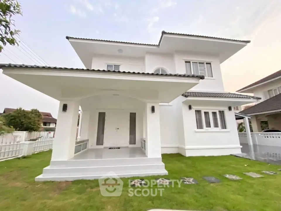 Elegant two-story white house with modern design and lush green lawn, perfect for family living.