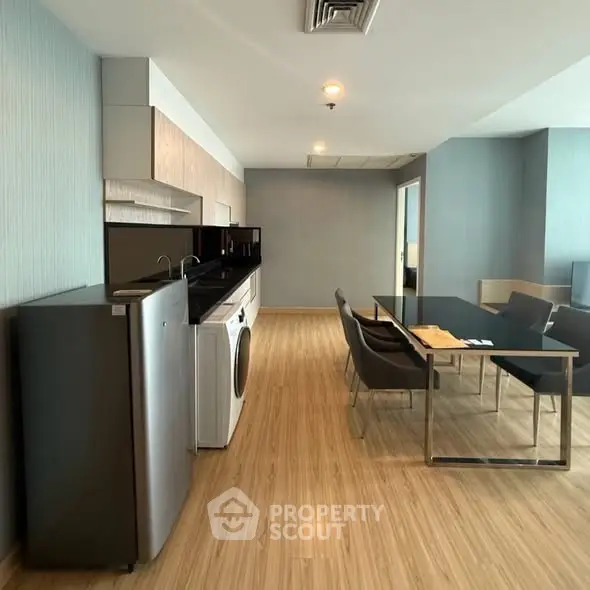 Modern open-plan living room with sleek kitchen appliances and stylish dining area.