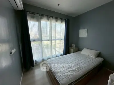 Cozy bedroom with large window and modern decor, perfect for relaxation.