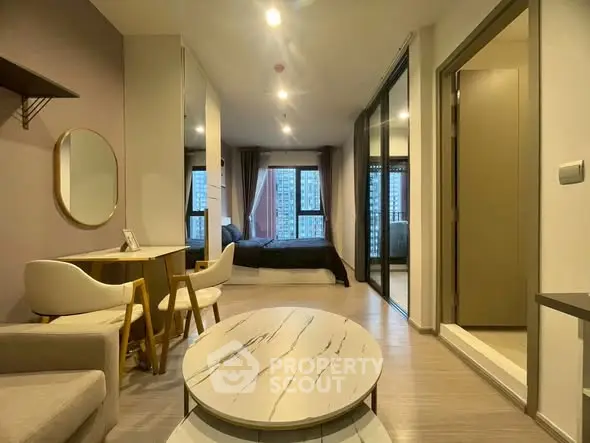 Modern studio apartment with stylish decor and large windows offering city views.