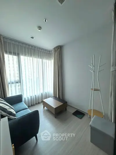 Bright living room with modern furniture and large windows in a stylish apartment.