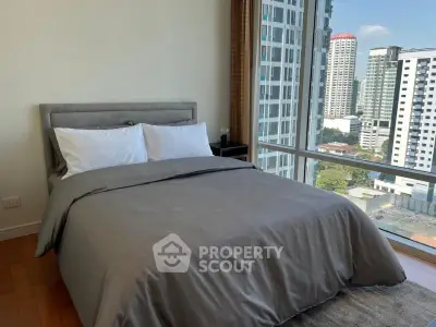 Modern bedroom with city view and large windows in high-rise apartment
