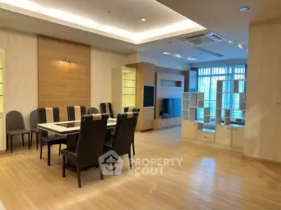Spacious modern dining and living area with elegant wooden flooring and stylish furniture.