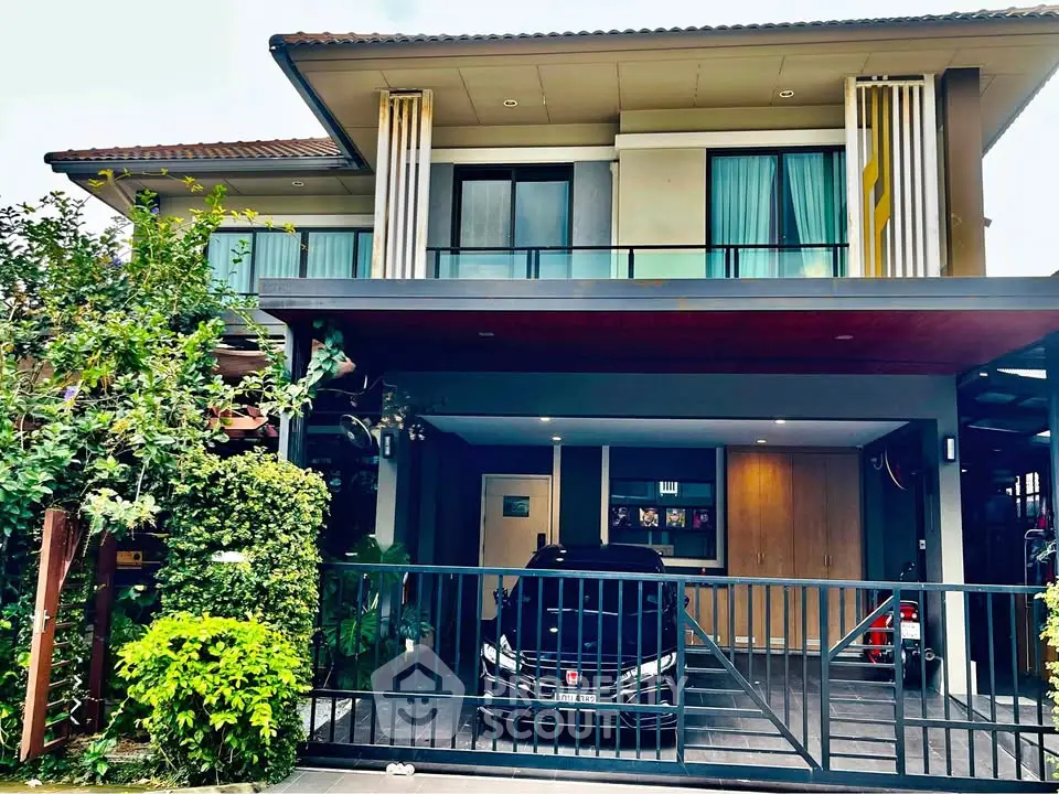 Modern two-story house with carport and lush greenery in front yard