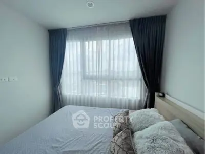 Cozy bedroom with large window and elegant curtains, perfect for natural light lovers.
