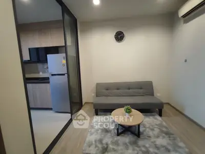 Modern living room with sleek sofa and stylish kitchen view