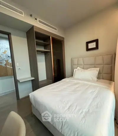 Cozy bedroom with modern design and built-in closet, perfect for relaxation.