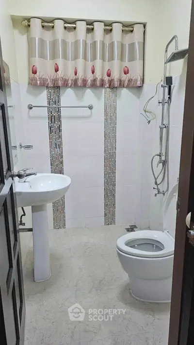 Compact bathroom with modern fixtures and stylish wall tiles, perfect for urban living.