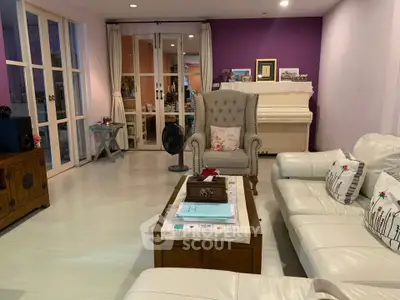 Spacious living room with elegant white furniture and a piano, perfect for relaxation and entertainment.