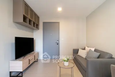 Modern living room with sleek furniture and neutral tones, featuring a cozy sofa and flat-screen TV.
