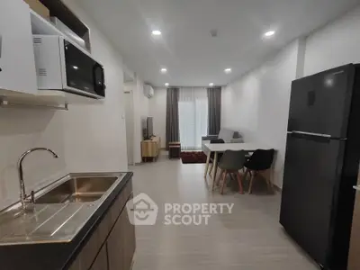 Modern open-plan kitchen and living area with sleek appliances and stylish furniture.