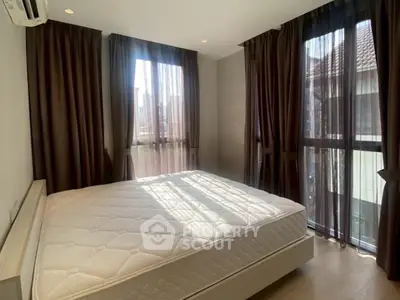 Bright bedroom with large windows and modern decor in a stylish apartment.