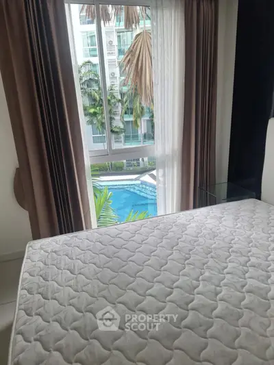 Bedroom with pool view, featuring a large window and modern design.
