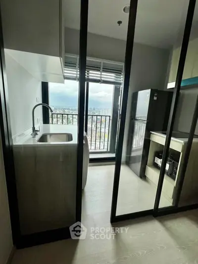 Modern kitchen with open layout and stunning city view from high-rise apartment.