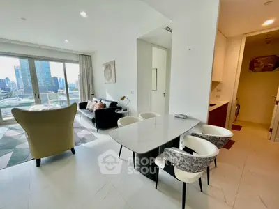 Modern open-plan living room with dining area and city view, featuring stylish furniture and large windows.