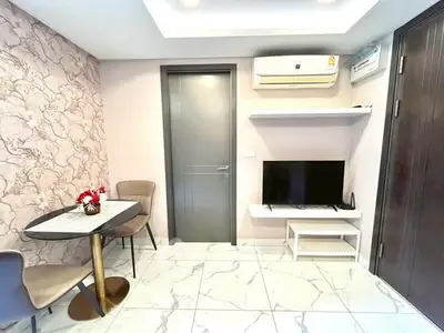 Modern living room with stylish decor, air conditioning, and a cozy dining area.