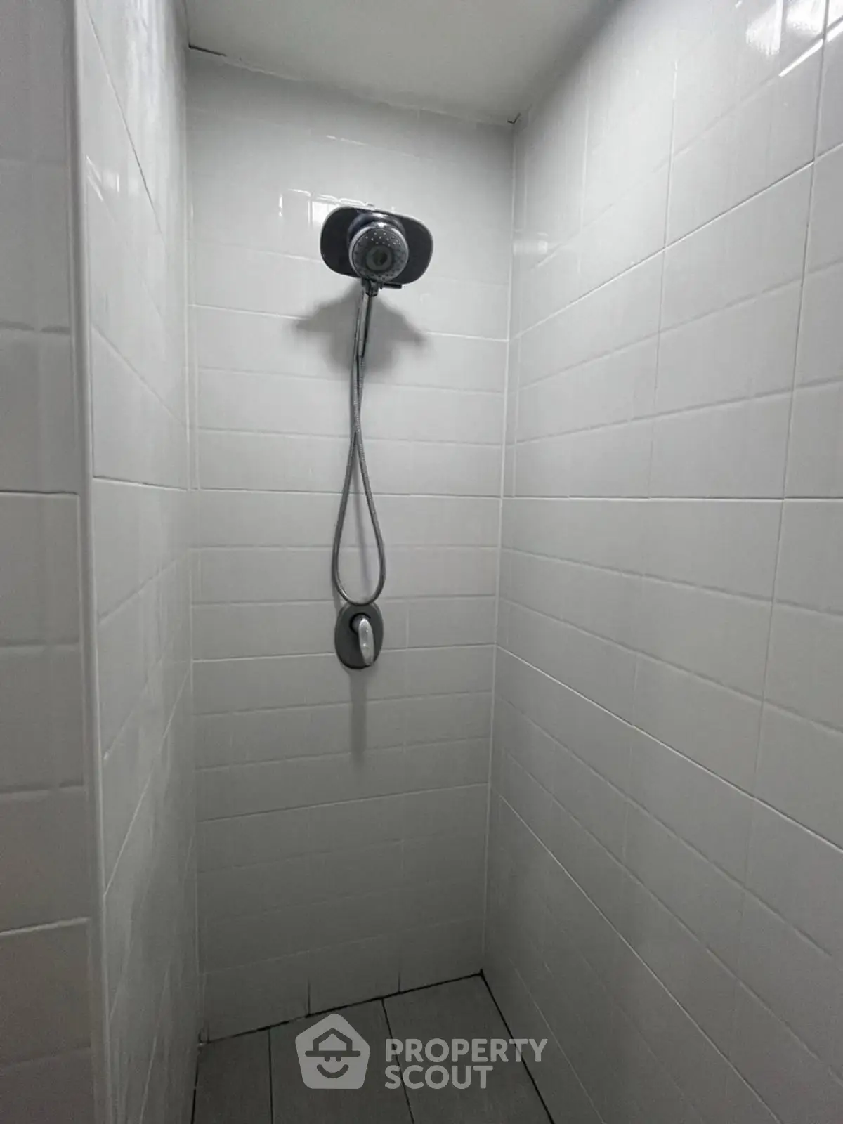 Modern minimalist shower with sleek white tiles and contemporary fixtures.