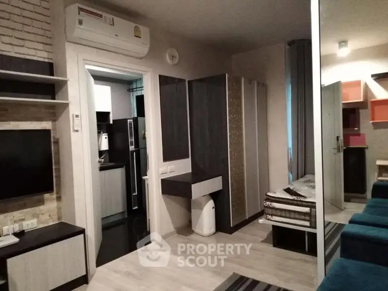 Modern studio apartment with sleek design and efficient layout, featuring a cozy living area and compact kitchen.