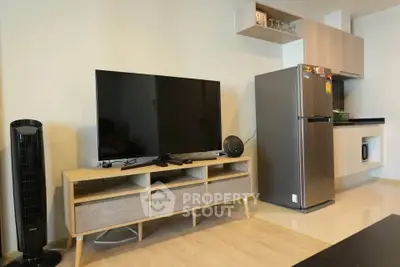 Modern living room with sleek TV setup and contemporary kitchen appliances.