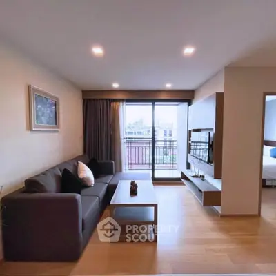 Modern living room with balcony view, sleek furniture, and natural light in a stylish apartment.