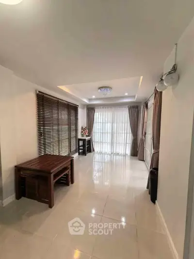 Spacious living room with elegant lighting and large windows for natural light.