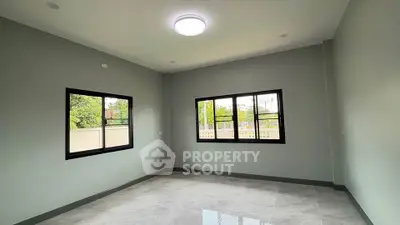 Spacious empty room with large windows and modern lighting, perfect for customization.
