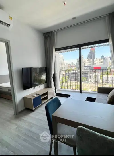 Modern living room with city view, featuring sleek furniture and large windows for natural light.