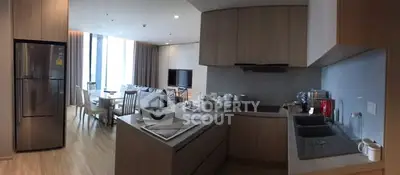 Modern open-layout kitchen and living area with sleek appliances and stylish decor.