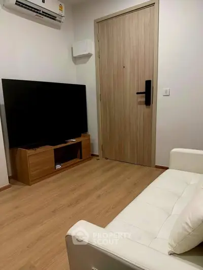 Modern living room with sleek TV setup and stylish wooden flooring.