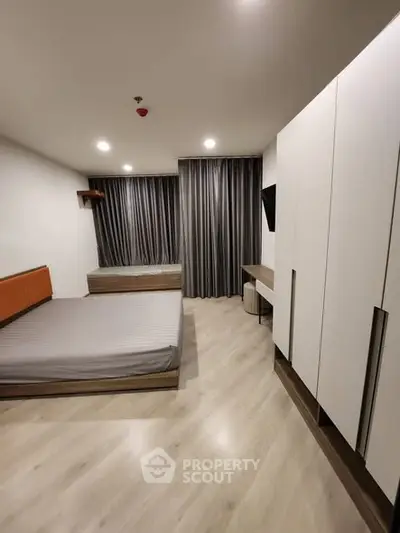 Modern bedroom with sleek design, featuring a large bed, stylish wardrobe, and elegant curtains.