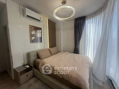 Modern bedroom with elegant lighting and large windows for natural light.