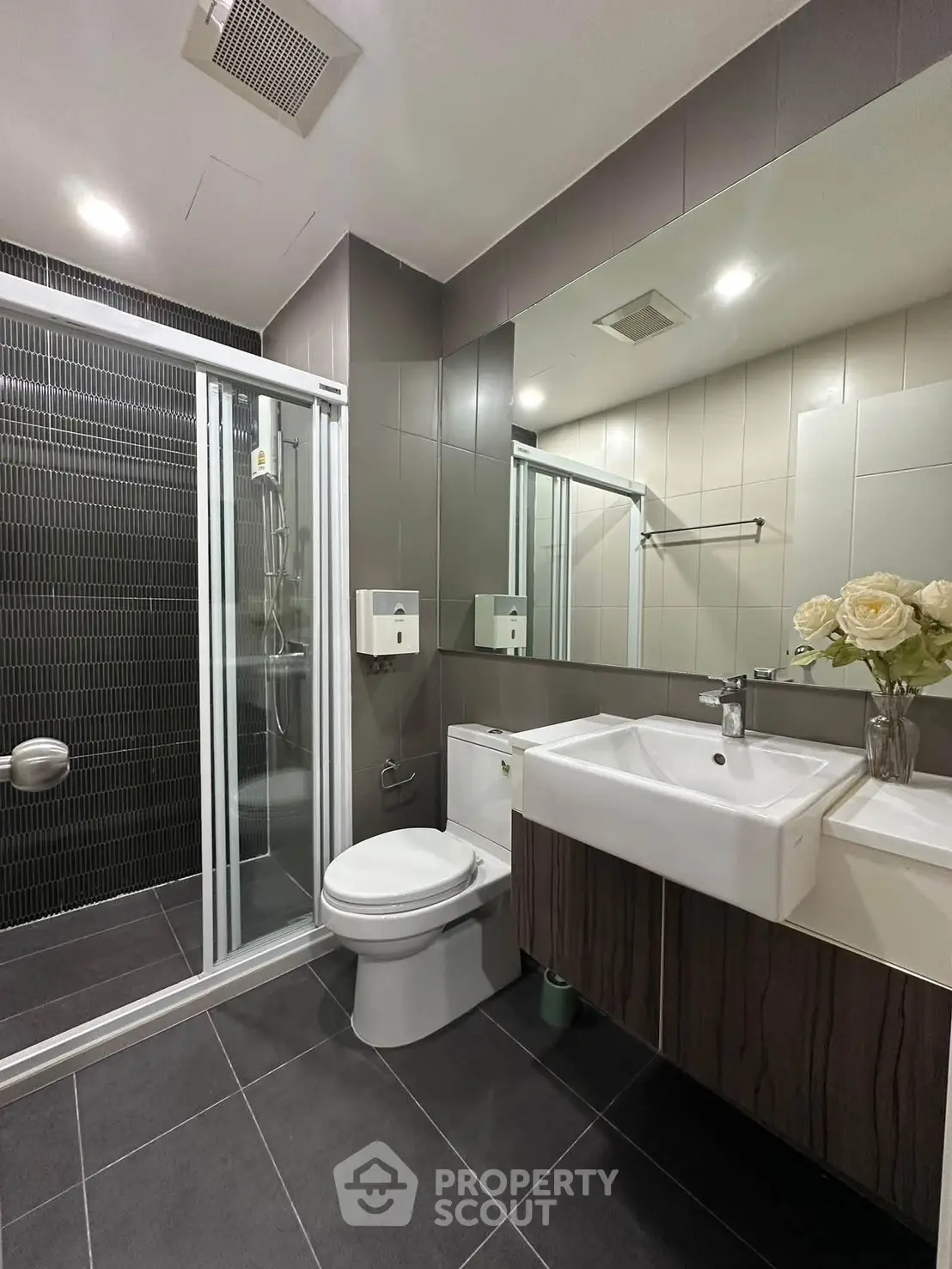 Modern bathroom with sleek design, featuring a glass shower, stylish sink, and elegant tile work.