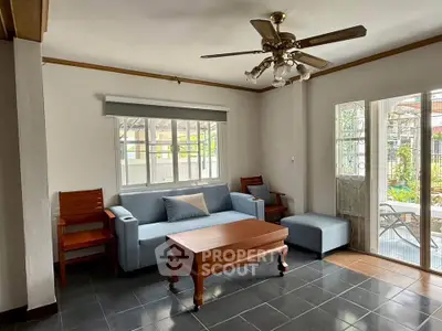 Charming living room with cozy sofa, wooden furniture, and garden view.