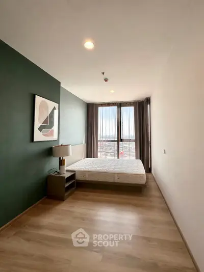 Modern bedroom with large window and stylish decor in a high-rise apartment.