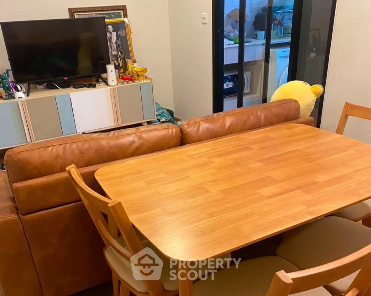 Cozy living room with leather sofa and wooden dining table, perfect for modern living.