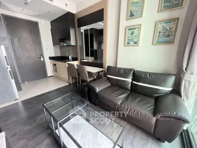 Modern living room with sleek furniture and open kitchen layout in a stylish apartment.
