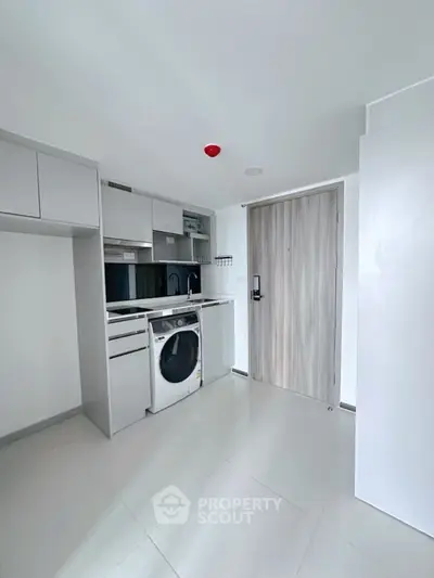 Modern compact kitchen with washing machine and sleek cabinetry