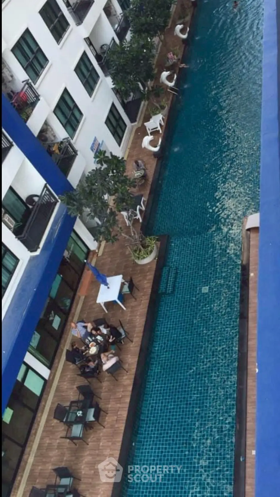 Luxurious apartment complex with a stunning outdoor pool and relaxation area.