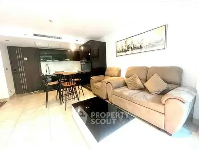 Modern living room with cozy sofa and open kitchen layout in a stylish apartment.